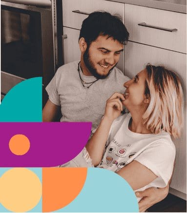 A young couple laughing together in a kitchen