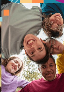 A group of young friends standing in a circle, looking down at the camera and smiling