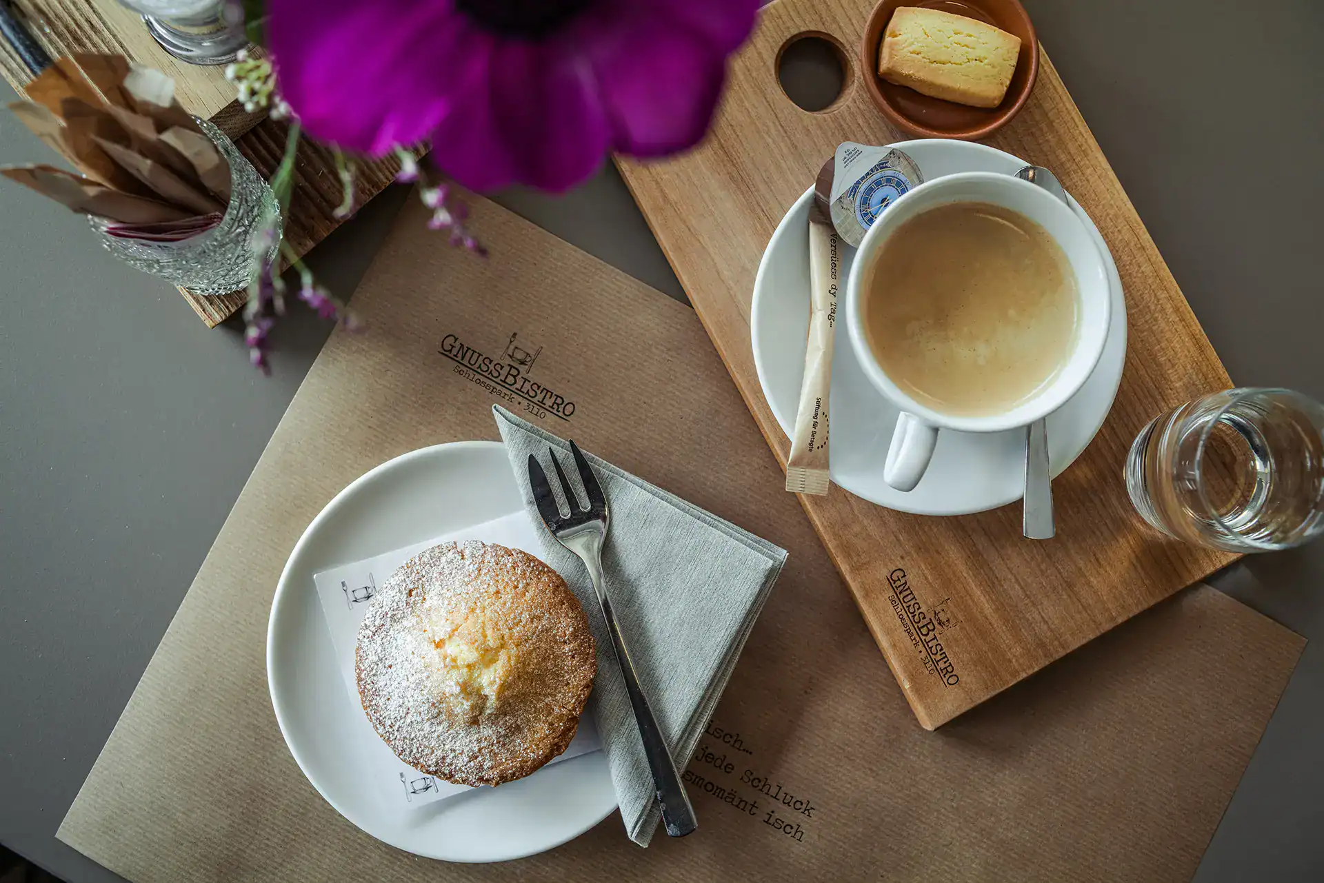 Tasse Kaffee mit Gebäck auf einem Holztablett