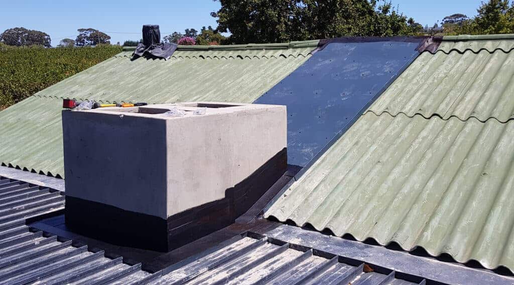 Custom aluminium roof flashings and waterproofing around chimney on Cape Town home.