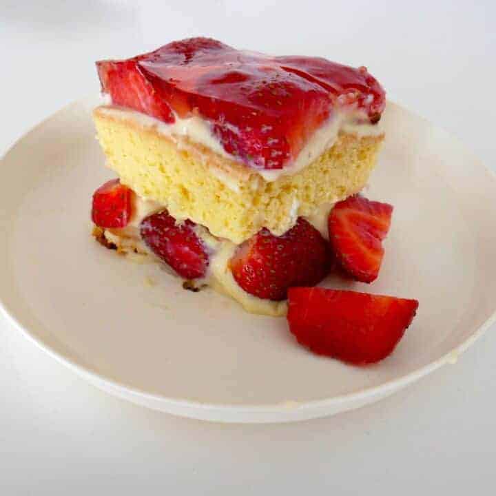 An authentic Polish Tort Truskawkowy, showcasing a slice of strawberry cake on a white plate.