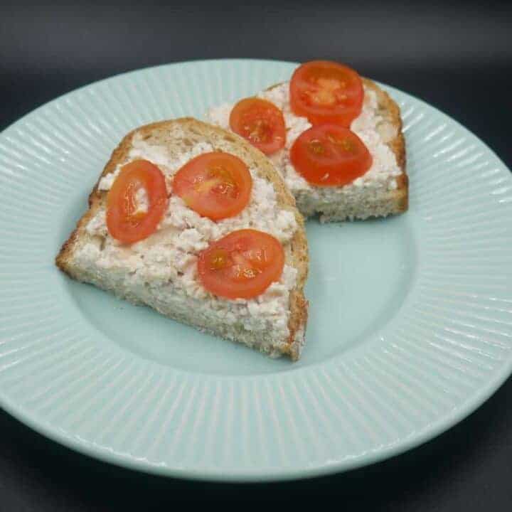 A plate with a slice of bread and tomatoes, representing Polish cuisine.