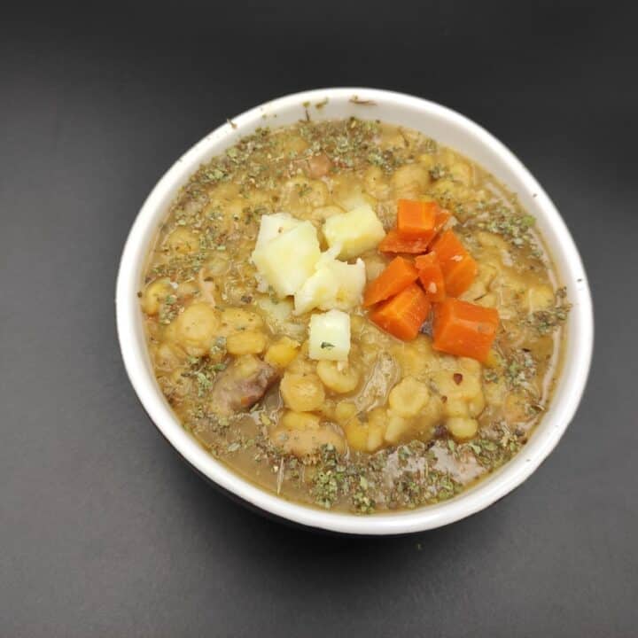 A bowl of Polish soup with carrots and potatoes.