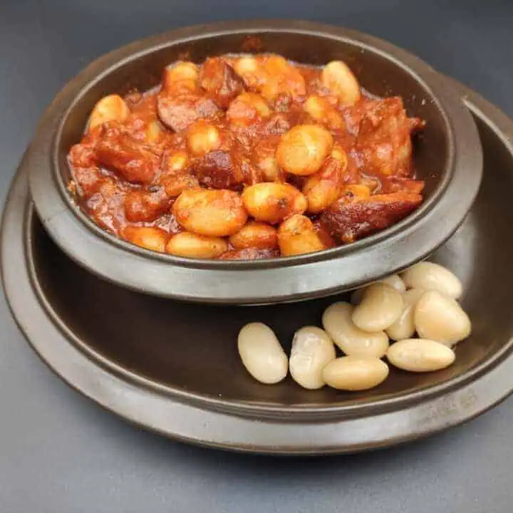 A bowl of beans on a black surface, showcasing the deliciousness of Polish cuisine.