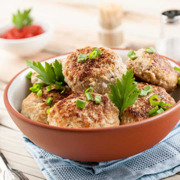 Kotlety mielone meatballs in a bowl on a wooden table.