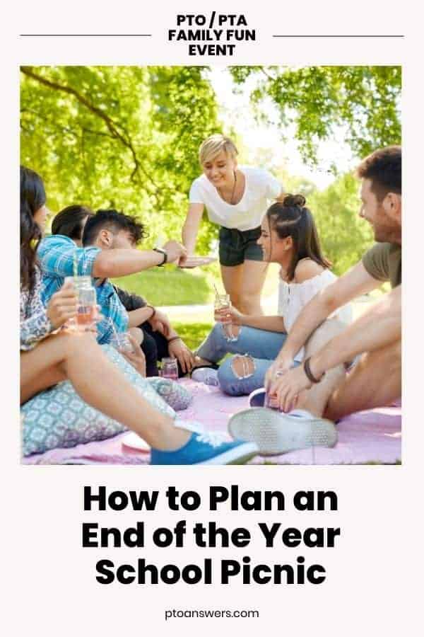 group of parents and kids gathered on picnic blanket outdoors on sunny day with trees in background
