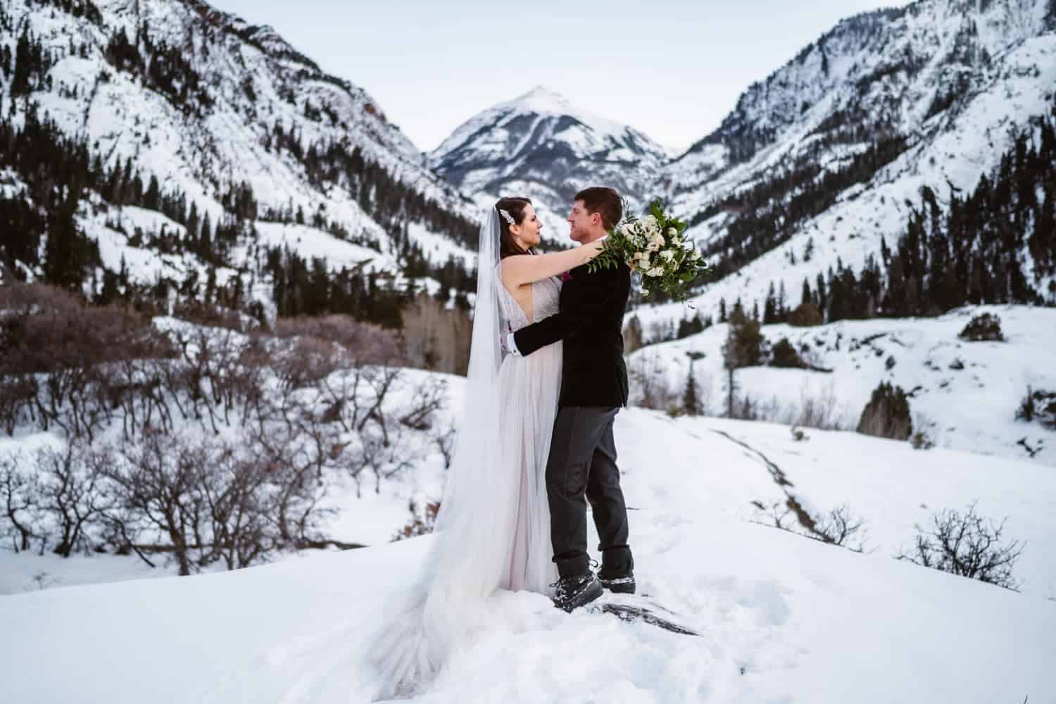 Bride and Groom Hugging in Snow during the winter in Colorado.