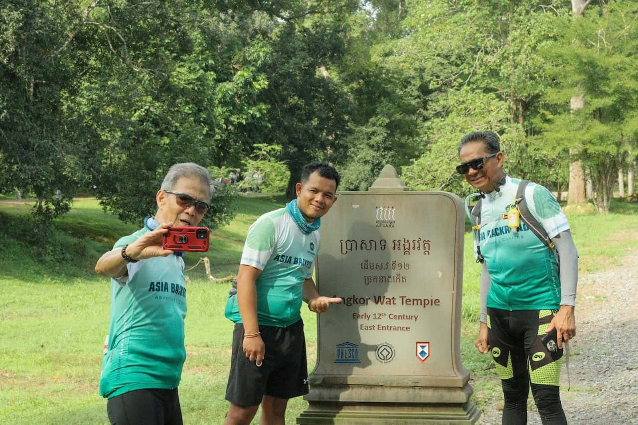 Cyclists exploring the countryside around Angkor Wat, riding through rural villages, rice fields, and scenic backroads near Siem Reap, Cambodia.