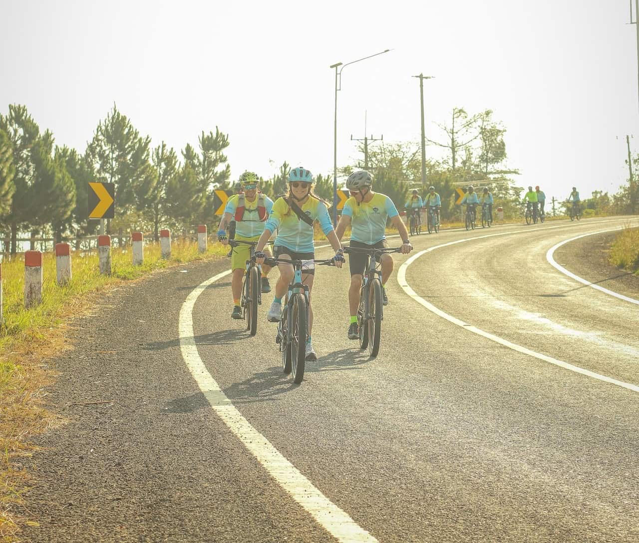 Cyclists traveling from Angkor Wat to Pakse on a scenic bike journey through Cambodia and Laos, passing rural villages, rice fields, and Mekong countryside backroads.