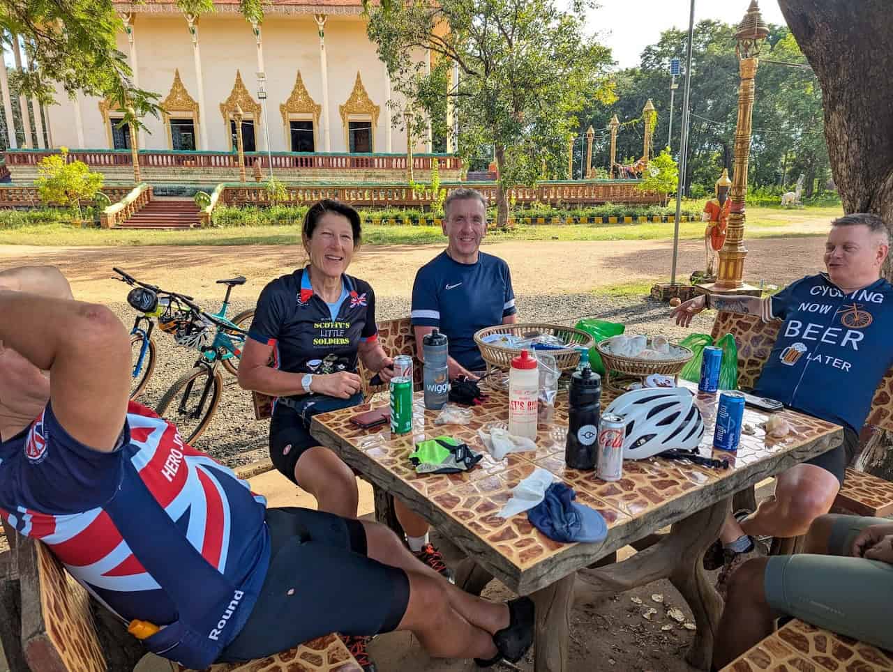 Cyclists riding through the Cambodia countryside near Tonle Sap Lake, passing rice fields, traditional Khmer villages, rural roads, and scenic agricultural landscapes.