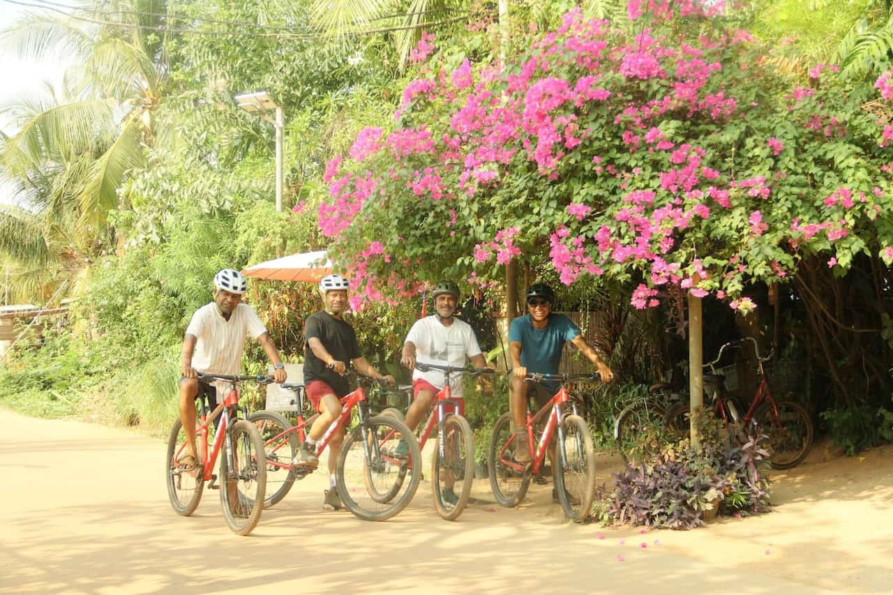 Cyclists traveling from Siem Reap to Phnom Penh on a long-distance backroad cycling adventure through rural Cambodia, passing rice fields, villages, and countryside landscapes.