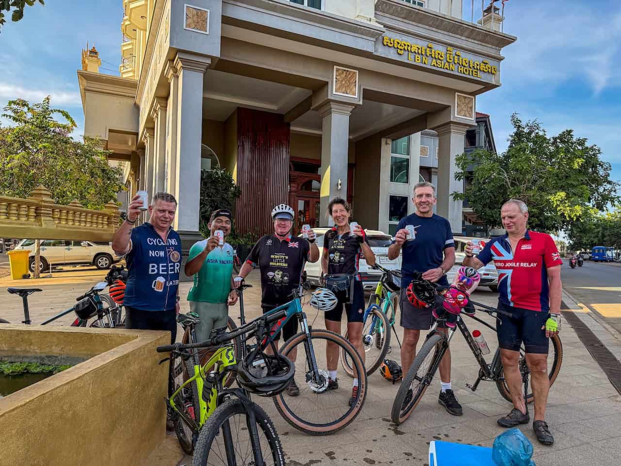 Cyclists riding through the Mekong region of Cambodia and Laos, following scenic backroads past rural villages, rice fields, riverside communities, and peaceful countryside landscapes.