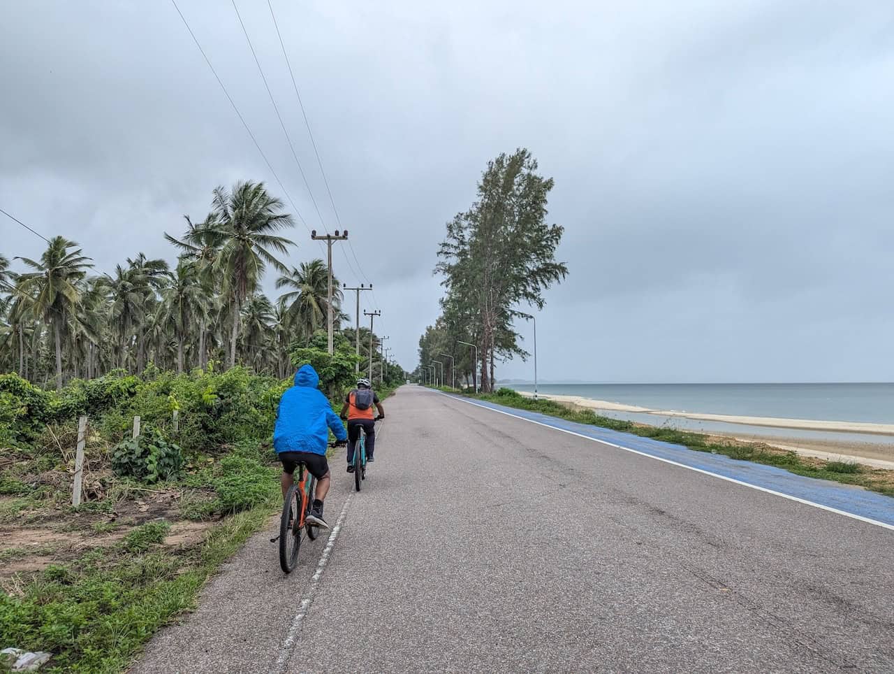 Cyclists riding along Thailand’s scenic coastal roads toward Krabi, enjoying tropical beaches, limestone cliffs, palm trees, and quiet seaside routes from Bangkok.