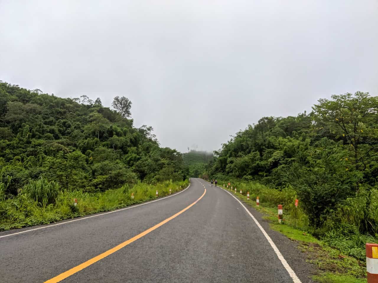 Road cyclists riding through spectacular mountain landscapes on a Southeast Asia cross-border road cycling tour across Indochina.