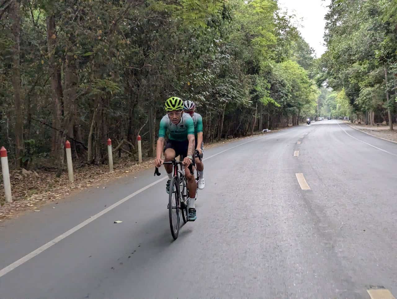 Cyclists enjoying an Indochina road bike adventure on a Southeast Asia cross-border road cycling tour through scenic countryside.