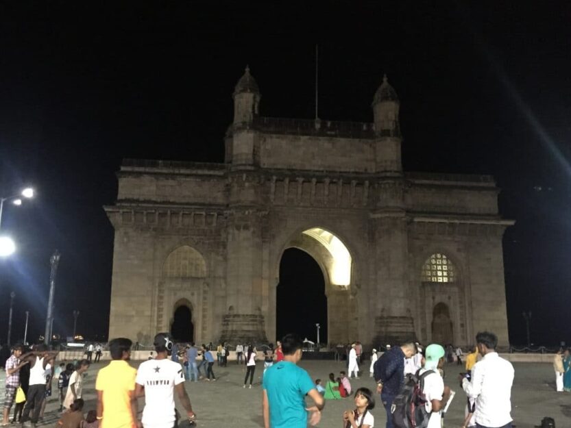 Gateway of India in Coloba, Mumbai Gateway of India in Coloba Mumbai lit up at night with many people in the foreground.
