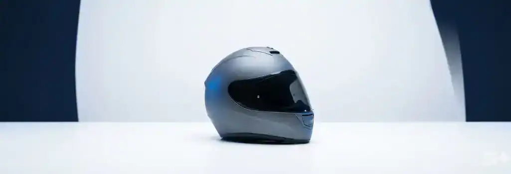 Sleek slate gray motorcycle helmet resting on a clean white surface, representing rider safety and strategic legal protection.