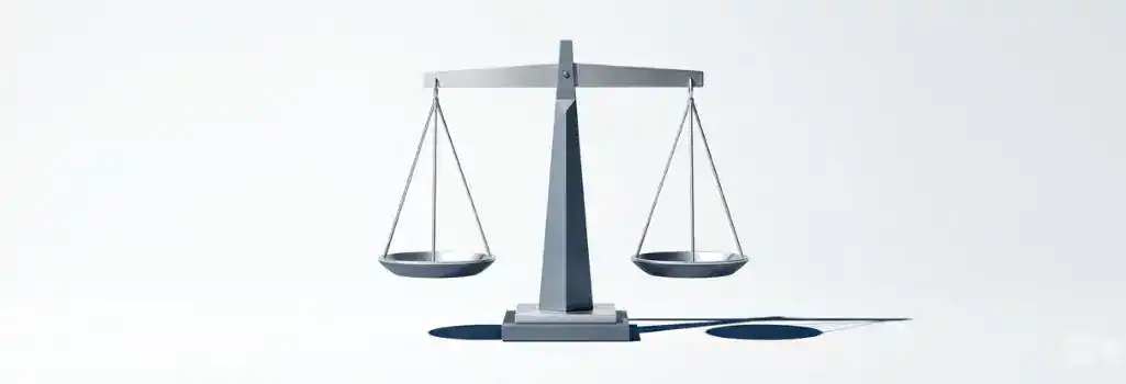 A modern silver scale of justice resting on a clean white surface, representing financial equity and fair compensation in legal settlements.