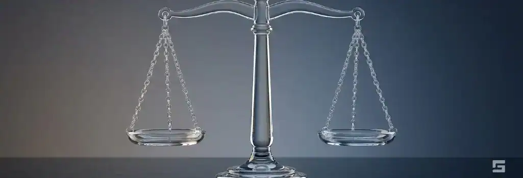 Clear glass Scales of Justice on a navy and slate background, weighing the value of a personal injury lawsuit. Grano Law Offices, P.C. injury representation.