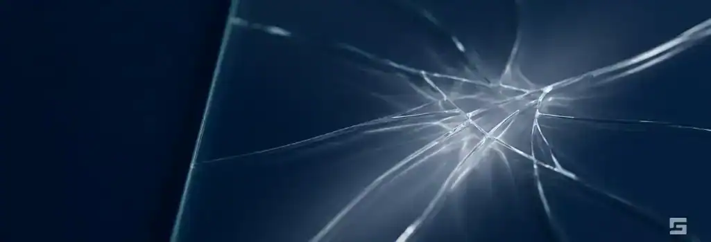 Abstract fractured clear glass on a navy blue background, representing a breach of trust in bad faith insurance claims. Grano Law Offices, P.C.