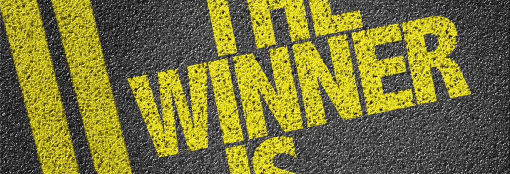 A paved road with double yellow lines, next to the words "The Winner Is..."