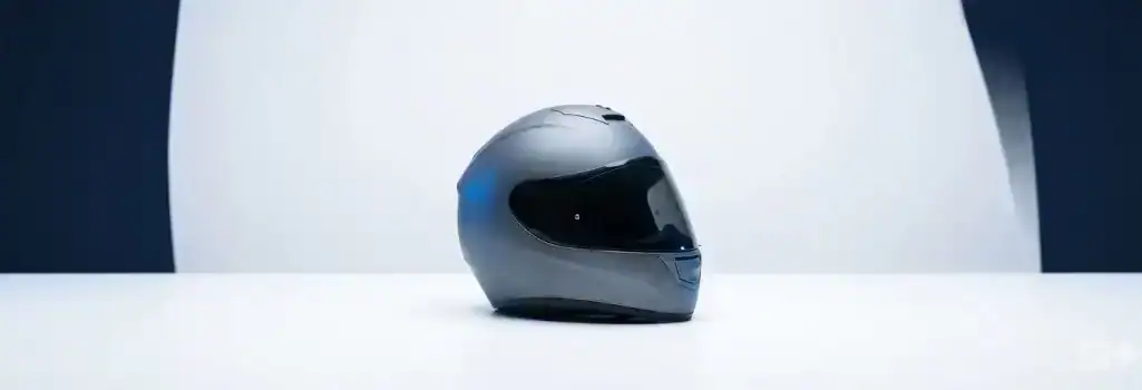 Sleek slate gray motorcycle helmet resting on a clean white surface, representing rider safety and strategic legal protection, representing the steps to take after a motorcycle accident in New Mexico.