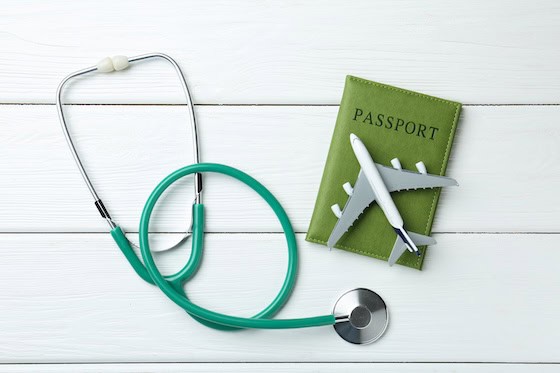Medical tourism. Stethoscope, plane model and passport on white