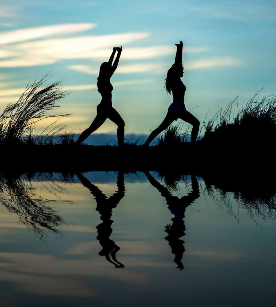 a silhouette of two women doing yoga