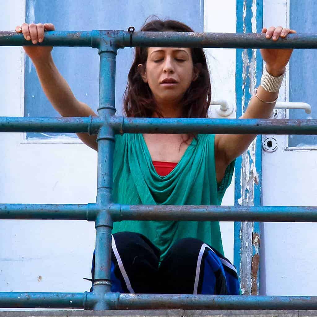 a woman sitting on a blue railing