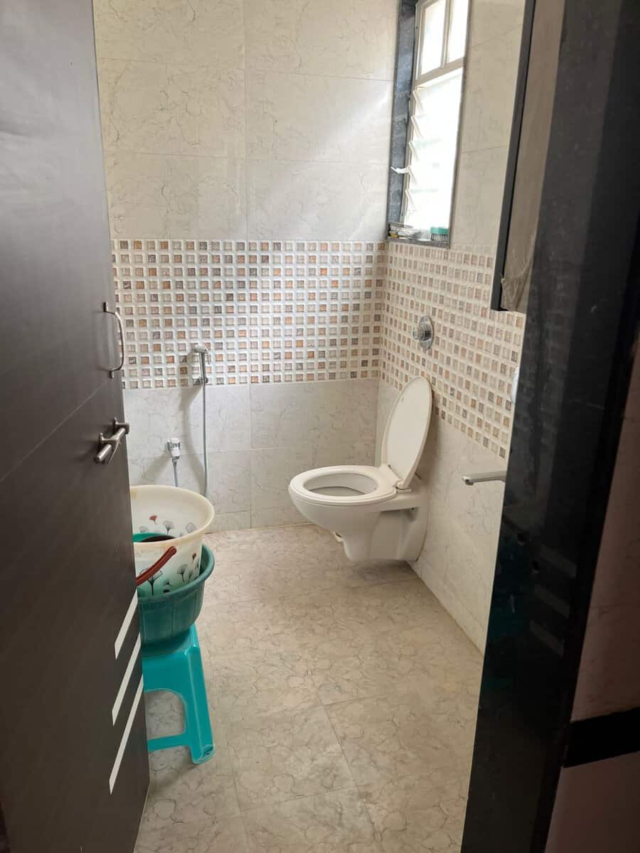 Common bathroom with mosaic border tiles and geyser in GK Aarcon flat Punawale