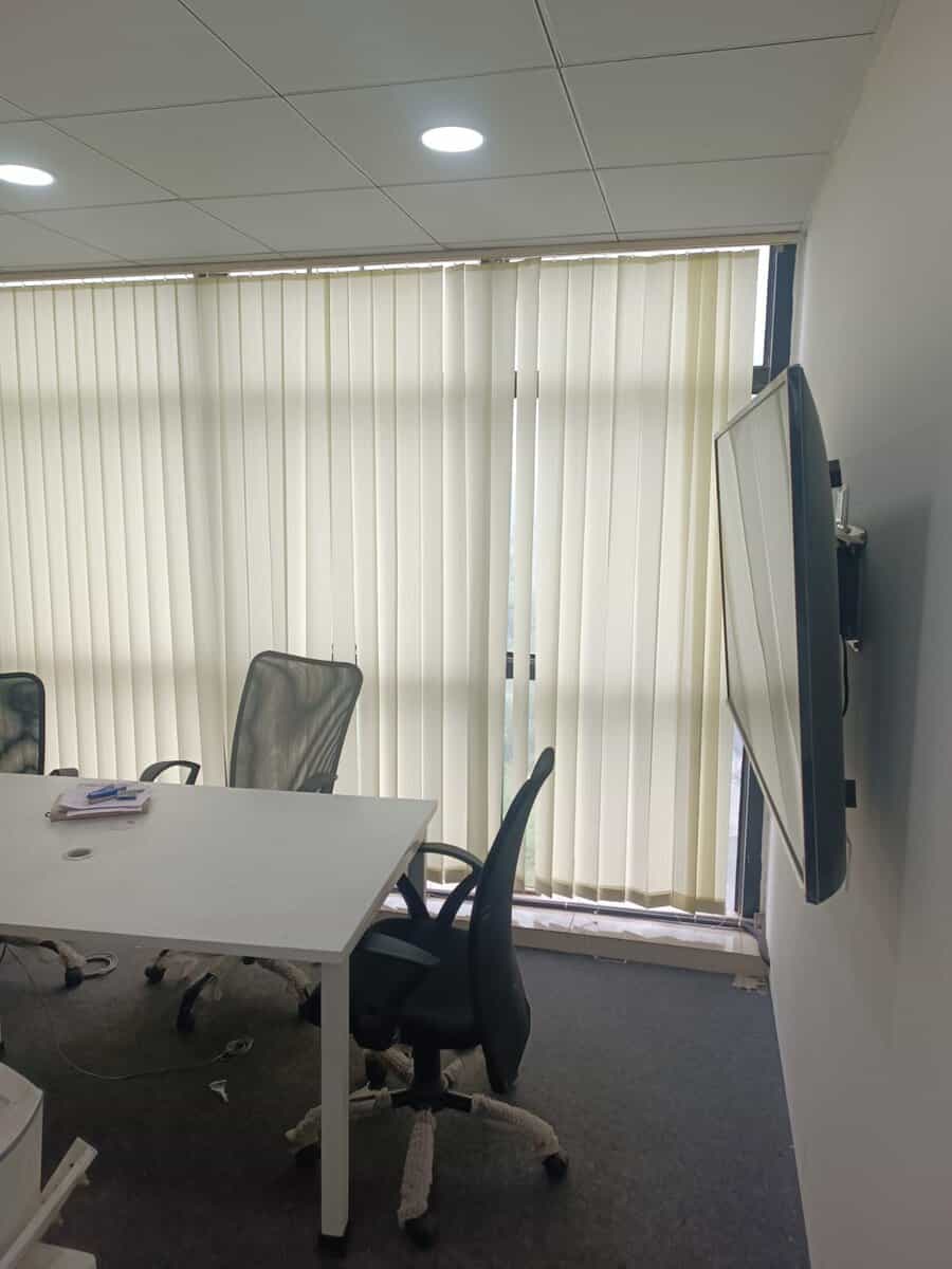 Conference room with wall-mounted display and vertical blinds in furnished office for rent at Suratwala Mark Plazzo Hinjewadi