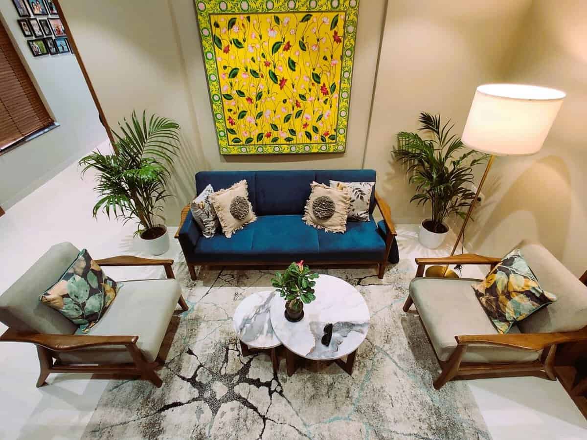 Fully furnished 3 BHK living room in Mount Unique Residence Baner Pune with teak sofa and wall art
