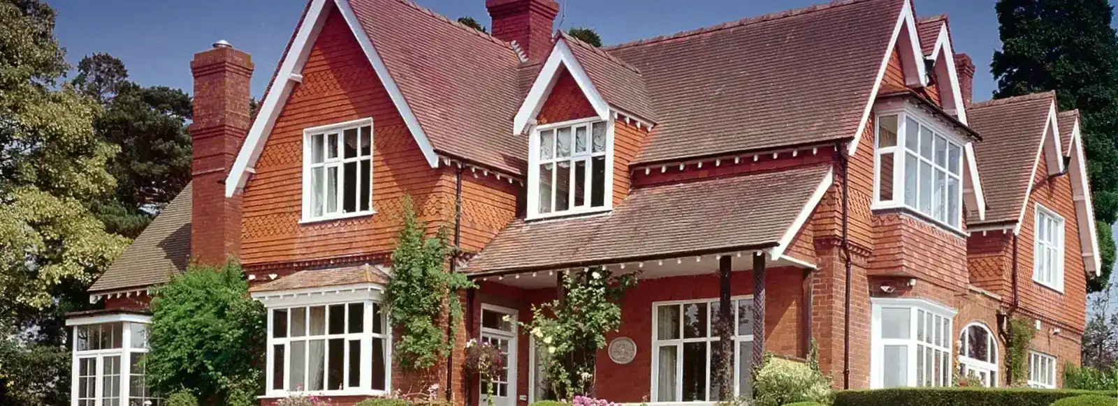 house made of bricks with multiple different types of window installed in it