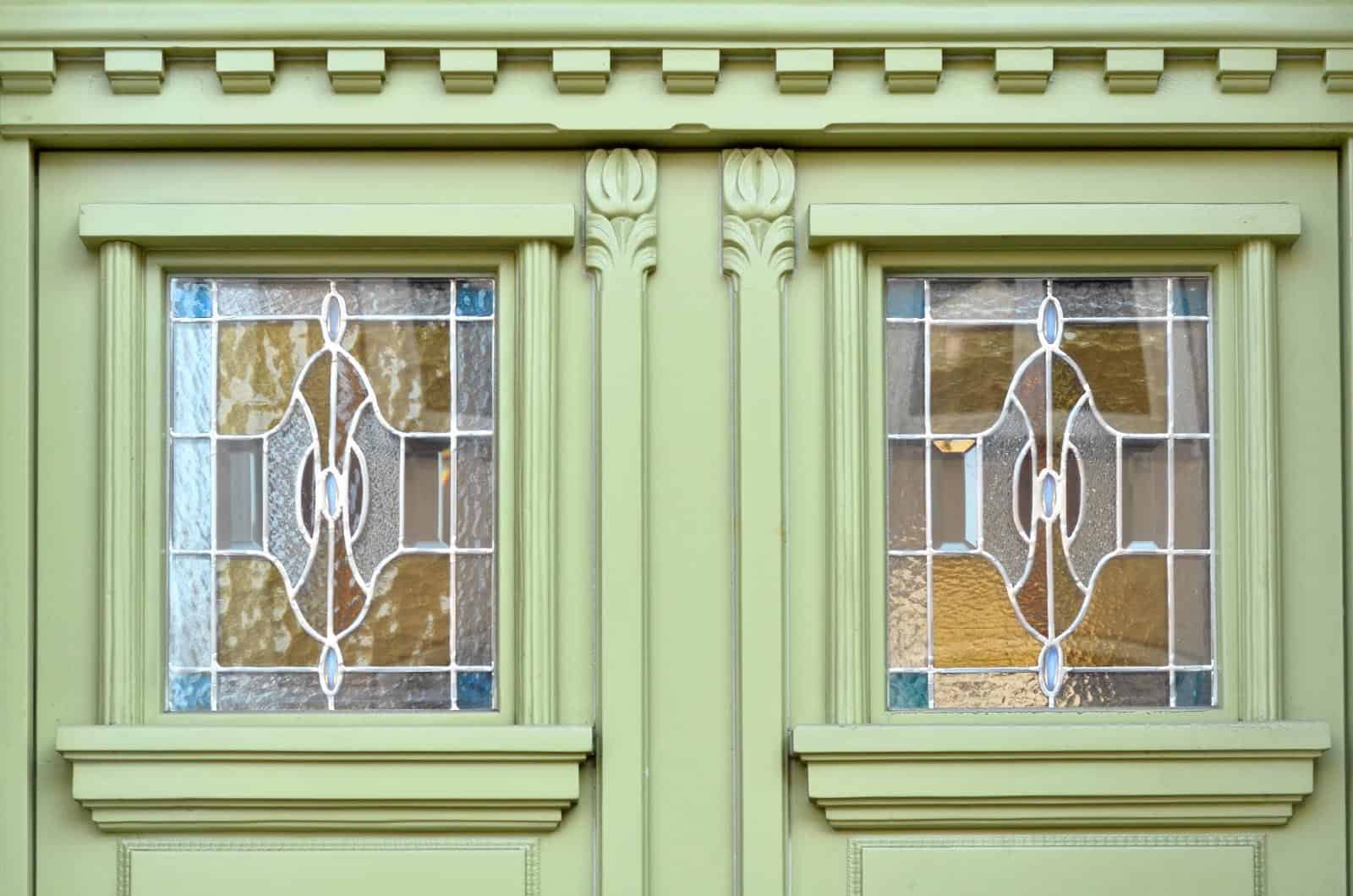 Green wooden door with stained glass