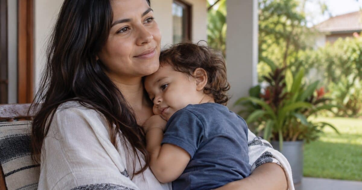 Criança pequena descansando junto à mãe na varanda de casa, em uma cena de tranquilidade que ilustra o Salmo 131.