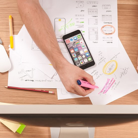 Person writing on papers on a desk 